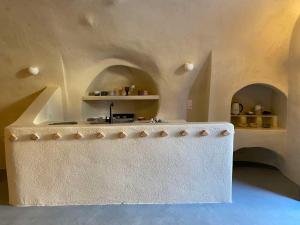 a kitchen with arches and a counter in a room at Amphora Villas Oia Santorini in Foinikiá