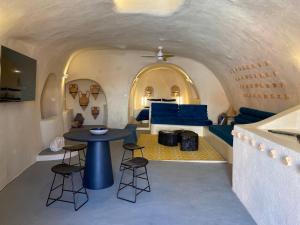 a room with a table and chairs and a bed at Amphora Villas Oia Santorini in Foinikiá