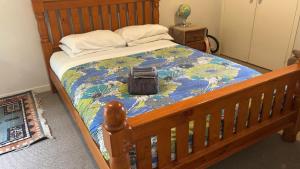 a bed with a wooden frame with a bag on it at 25 Glenfell Place - One Bedroom Studio in Auckland