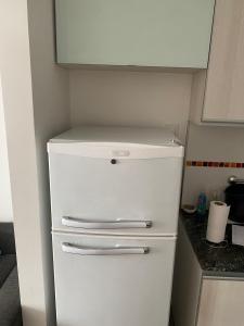 a small white refrigerator in a small kitchen at Departamento con yacuzzi centrico in San Lorenzo