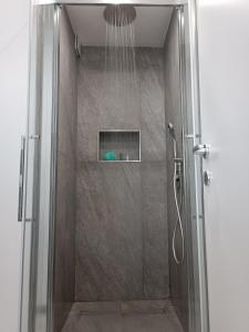 a shower with a glass door in a bathroom at Clio's House - Mondello in Mondello