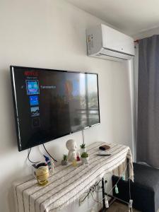 TV de pantalla plana colgada en la pared en Departamento con yacuzzi centrico en San Lorenzo