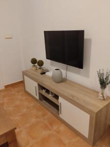 telewizor z płaskim ekranem na ścianie w salonie w obiekcie Marina Vistamar w mieście Mojácar