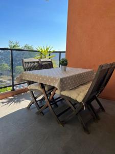 una mesa y sillas en un balcón con vistas en Très joli 2 pièces calme ensoleillé avec piscine en Niza