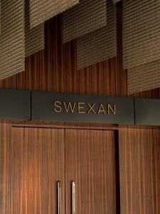 a building with a sign that readsswexarma at Hôtel Swexan in Dallas