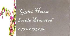 a sign for a guest house with flowers on it at Fully Equipped Modern 3 bedroom House in Bishops Stortford