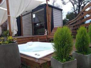 a tub on the deck of a tiny house at Modo tiny relax spa in Duggan