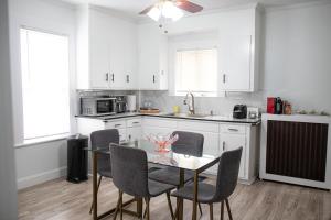 a kitchen with white cabinets and a table and chairs at Your Cozy and Relaxing Retreat in Woburn