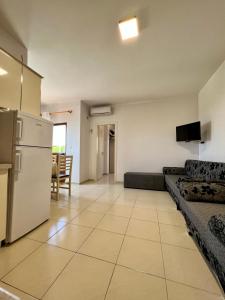uma ampla sala de estar com um sofá e um frigorífico em Kamberi Hotel & Apartments em Velipojë