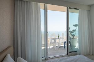 a bedroom with a bed and a large glass window at Unico Hotel Caorle in Caorle +37 photos