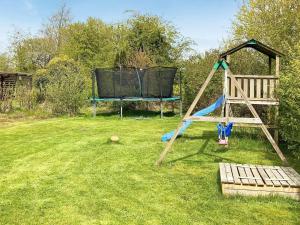 a playground with a slide and a swing at 6 person holiday home in Nørre Nebel-By Traum in Nørre Nebel