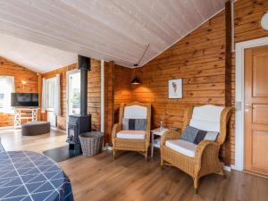 um quarto com uma parede de madeira com cadeiras e um fogão em Holiday home Fanø CXCVIII em Fanø