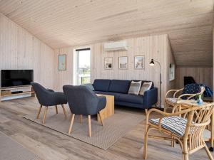 a living room with a blue couch and chairs at Holiday home Harboøre XXIII in Harboør