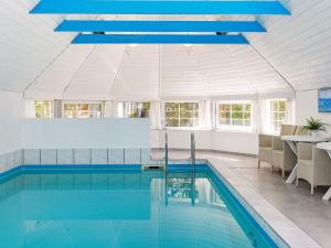 a swimming pool with a blue ceiling at 12 person holiday home in V ggerl se in Marielyst