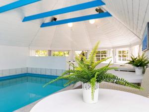 a pool with a table with a plant on it at 12 person holiday home in V ggerl se in Marielyst