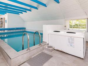 a swimming pool with a bath tub and a swimming pool at 12 person holiday home in V ggerl se in Marielyst