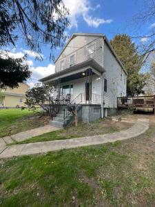 Cette grande maison blanche dispose d'une terrasse couverte et d'une cour. dans l'établissement Beautiful Updated House, 