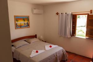 a bedroom with a bed with red crosses on it at Apartamentos da Jangada in Canoa Quebrada