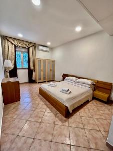 ein Schlafzimmer mit einem großen Bett und einem großen Fliesenboden in der Unterkunft Residence Villa il sogno in Rom