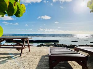 - une table de pique-nique et un banc sur la plage dans l'établissement moorea temae bungalow lory bord de mer, à Moorea