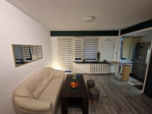 a living room with a couch and a table at Leśny Kącik tuż przy centrum miasta in Krosno +4 photos