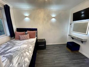 a bedroom with a bed and a flat screen tv at Chic 2 Bedroom Flat in Trimley Heath