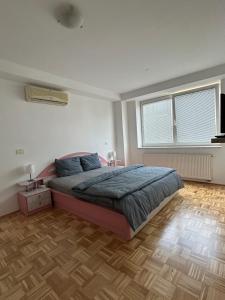 a bedroom with a bed and a wooden floor at Apartma Lunca 2 in Ljubljana
