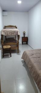 een slaapkamer met een bed, een stoel en een tafel bij Apartamento Romian in Paysandú