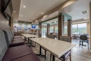 a dining room with tables and chairs and windows at Holiday Inn Express Golden-Kicking Horse by IHG in Golden