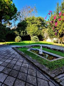 a garden with a fountain in the middle of a park at Lemuria Manor, Wine Dark Sea Villas in Rhodes Town