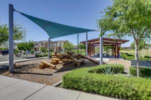 a park with a playground with a green canopy at Spacious Avondale Home with Patio and Pool Access! in Avondale