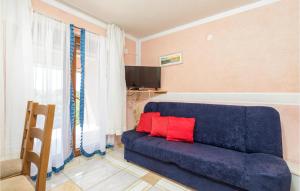 ein blaues Sofa im Wohnzimmer mit roten Kissen in der Unterkunft Amazing Apartment In Fazana With Kitchen in Fažana