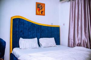 uma cama com uma cabeceira azul num quarto em Homey 2-Bed-Apt 24HRS POWER & Unlimited Internet Access em Lagos