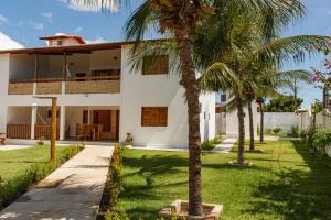 a house with palm trees in front of it at Apartamentos da Jangada in Canoa Quebrada