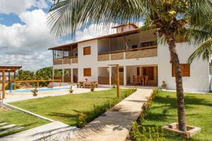a house with a palm tree in front of it at Apartamentos da Jangada in Canoa Quebrada