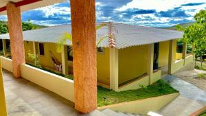a yellow house with a metal roof at Pousada Serra do Camulengo in Barra da Estiva