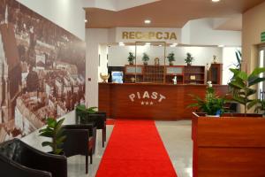 a lobby with a red carpet and a reception desk at Hotel Piast in Nysa