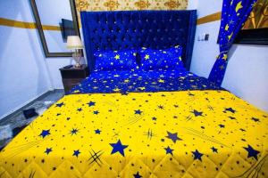 een slaapkamer met een geel bed met sterren erop bij Appartement meublé in Douala