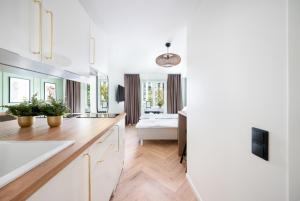 een keuken met witte kasten en een slaapkamer bij Tallinn Oasis Studios by RevalHome in Tallinn