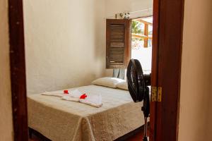 a bedroom with a bed with towels and a mirror at Apartamentos da Jangada in Canoa Quebrada