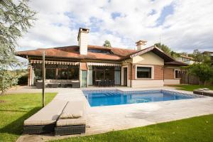 a house with a swimming pool in the yard at Golf & Pool in Basozábal
