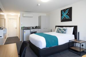 a hotel room with a bed and a kitchen at Bairnsdale International in Bairnsdale