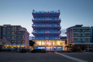 a tall building in front of two tall buildings at Unico Hotel Caorle in Caorle