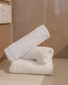 a stack of white towels sitting on a bathroom counter at Bairnsdale International in Bairnsdale