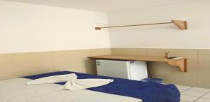 Habitación con cama y nevera pequeña. en Pousada Farol do Porto en Porto De Galinhas