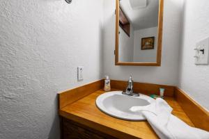a bathroom with a sink and a mirror at Shepherd's Cabin - Gambrel cabin, spacious while still being cozy and inviting! in Big Bear City +20 photos