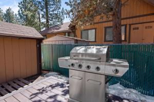 a grill sitting in a yard next to a fence at Shepherd's Cabin - Gambrel cabin, spacious while still being cozy and inviting! in Big Bear City