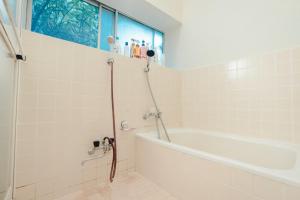 uma casa de banho com uma banheira e um chuveiro com uma janela em SLOW HOUSE kesennuma - Vacation STAY 31901v em Kesennuma