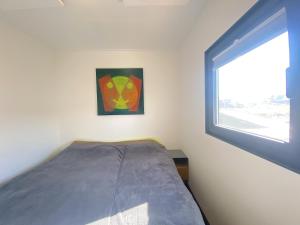 a small bedroom with a bed and a window at Woonboot Bertan in Nieuwpoort