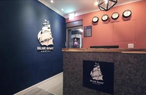a blue bar with clocks on the wall at Blueboat Hostel Jeonju in Jeonju